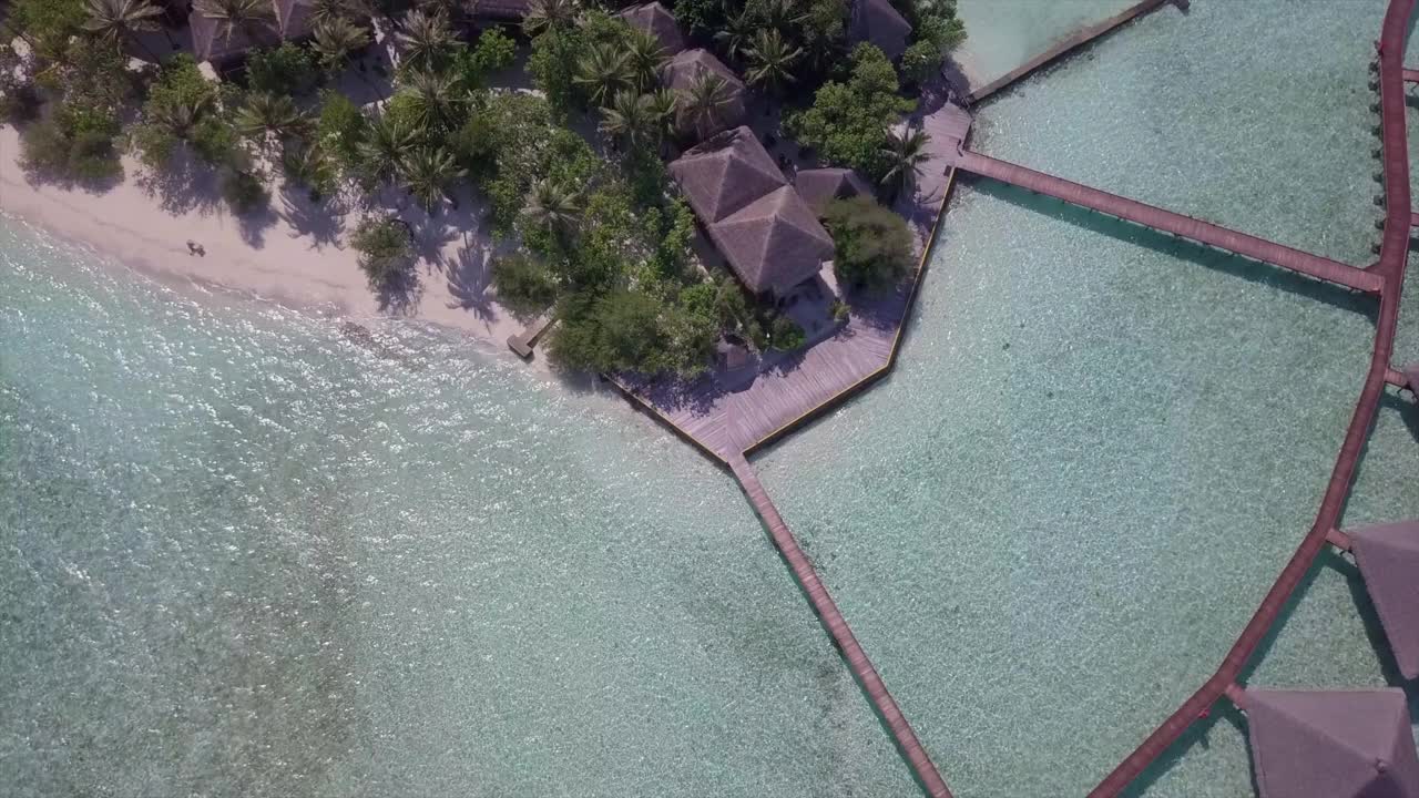 鸟瞰豪华度假岛在晴朗的一天，无人机下降在碧海上的Jetty - Vaadhoo，马尔代夫视频素材