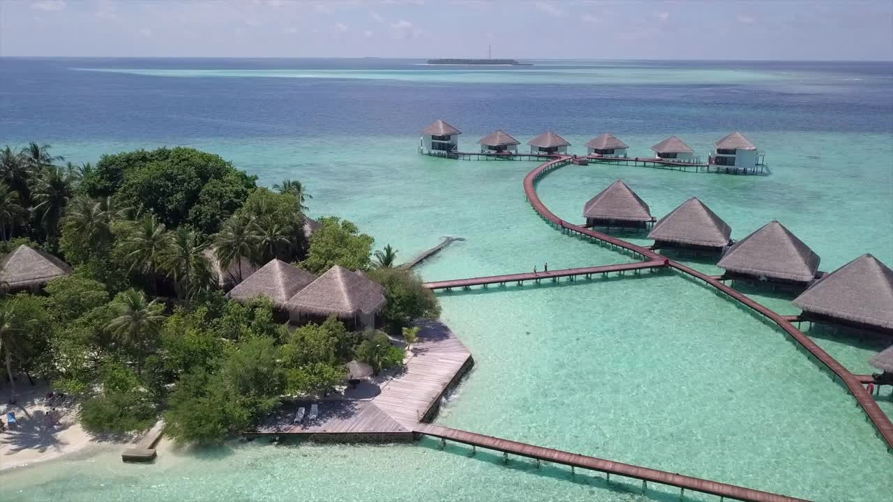 空中平移拍摄的水平房在豪华度假村的天空，无人机飞行在酒店游客在阳光明媚的一天-瓦都，马尔代夫视频素材
