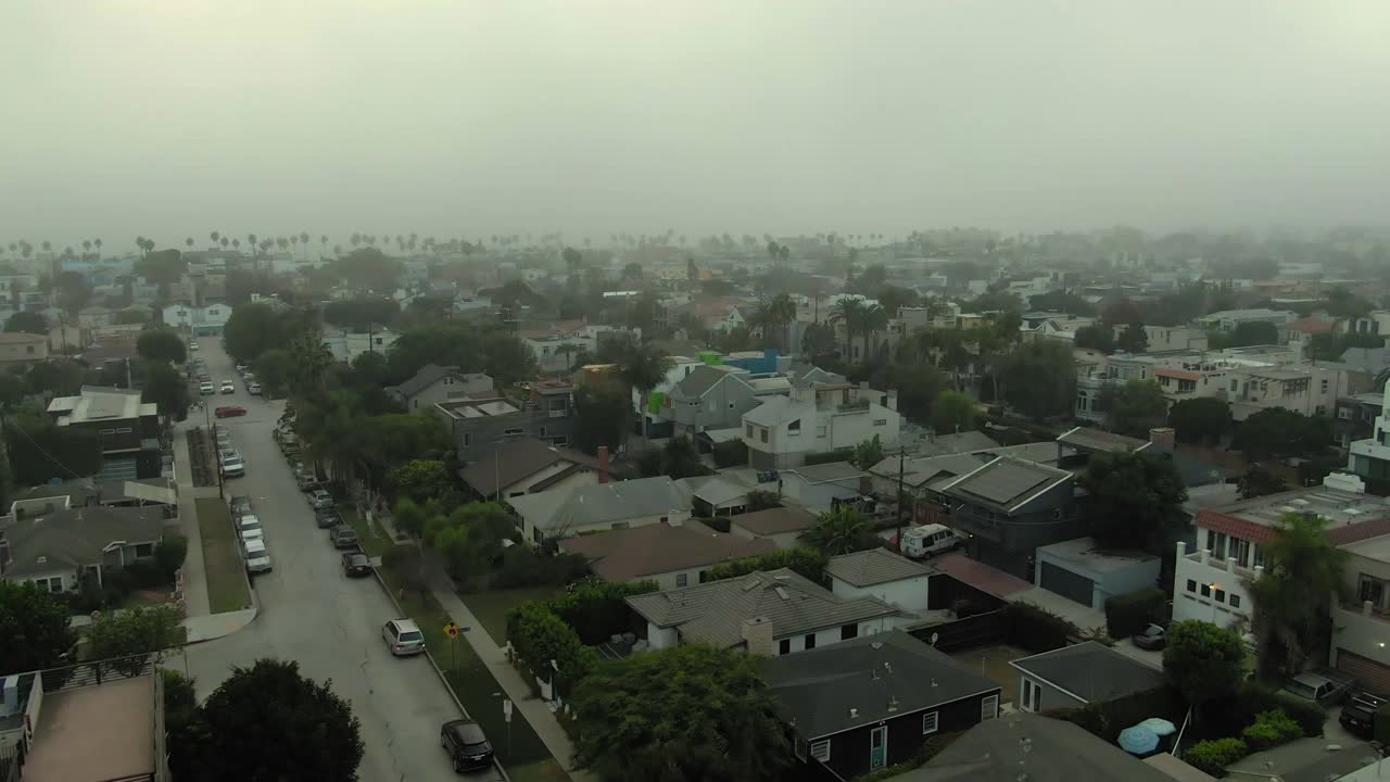 航拍的车辆在街道上的房子在威尼斯运河，无人机下降在城市对天空在日落-洛杉矶，加利福尼亚视频素材