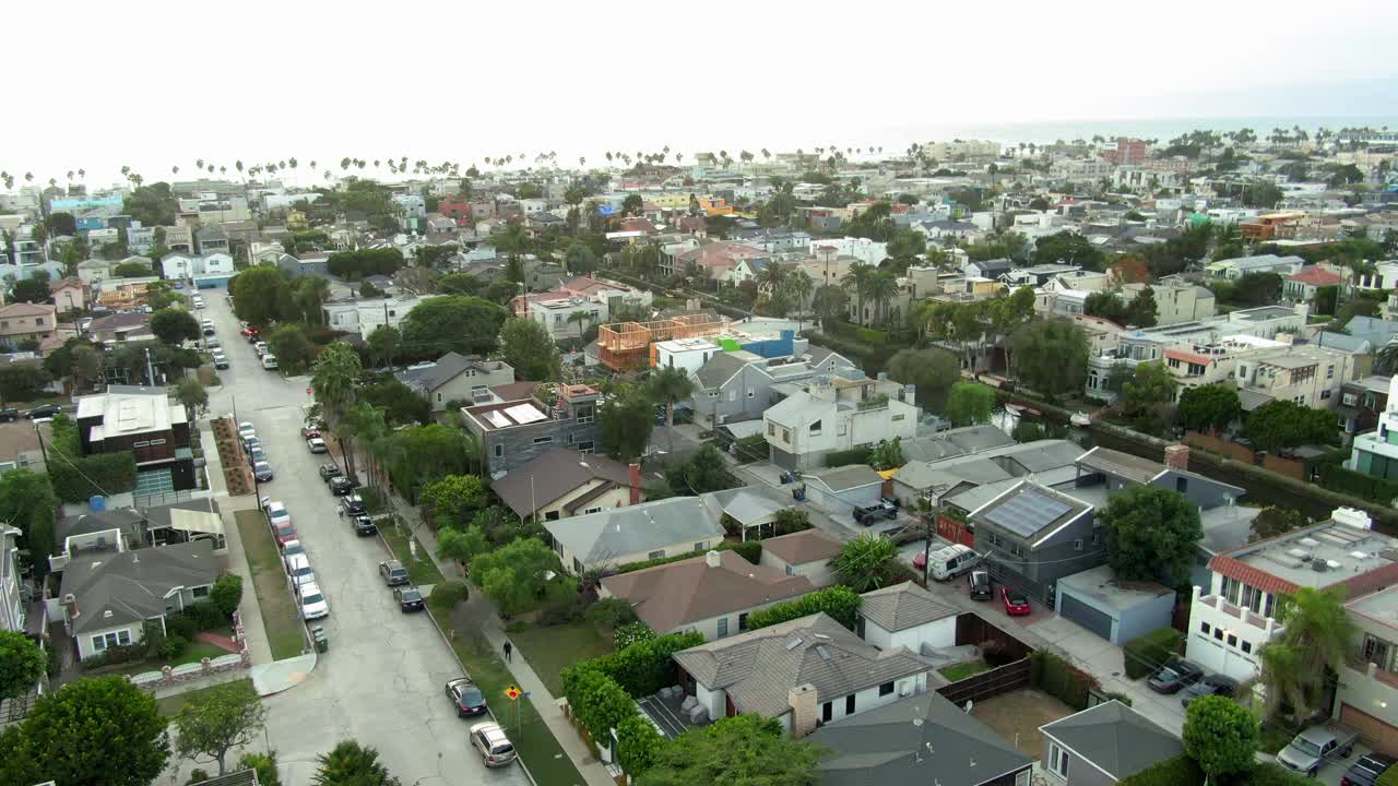 航拍的汽车在街上的房子在威尼斯运河，无人机下降城市对天空-洛杉矶，加利福尼亚视频素材