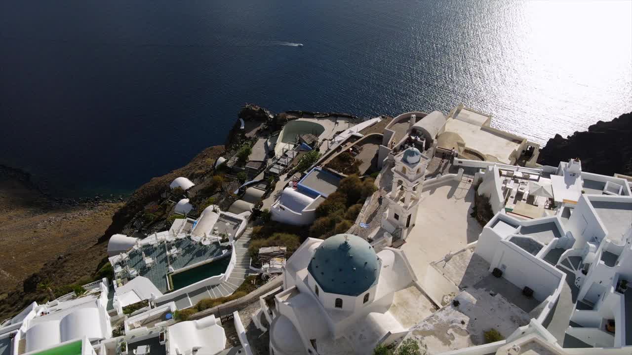 航拍拍摄著名的阿纳斯塔西东正教教堂在晴朗的一天，无人机飞过城市的海上-圣托里尼，希腊视频素材