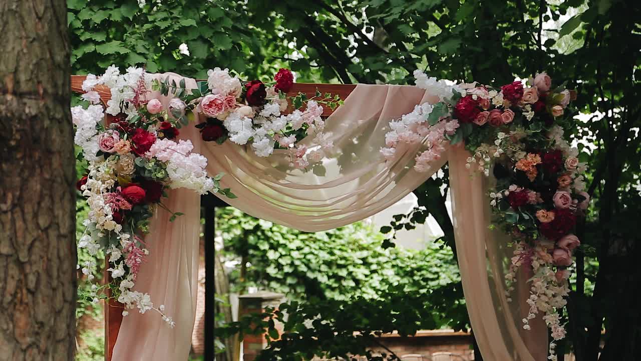 美丽绝伦的婚礼拱门装饰着美丽的鲜花。摄像机平滑地移动显示物体视频素材