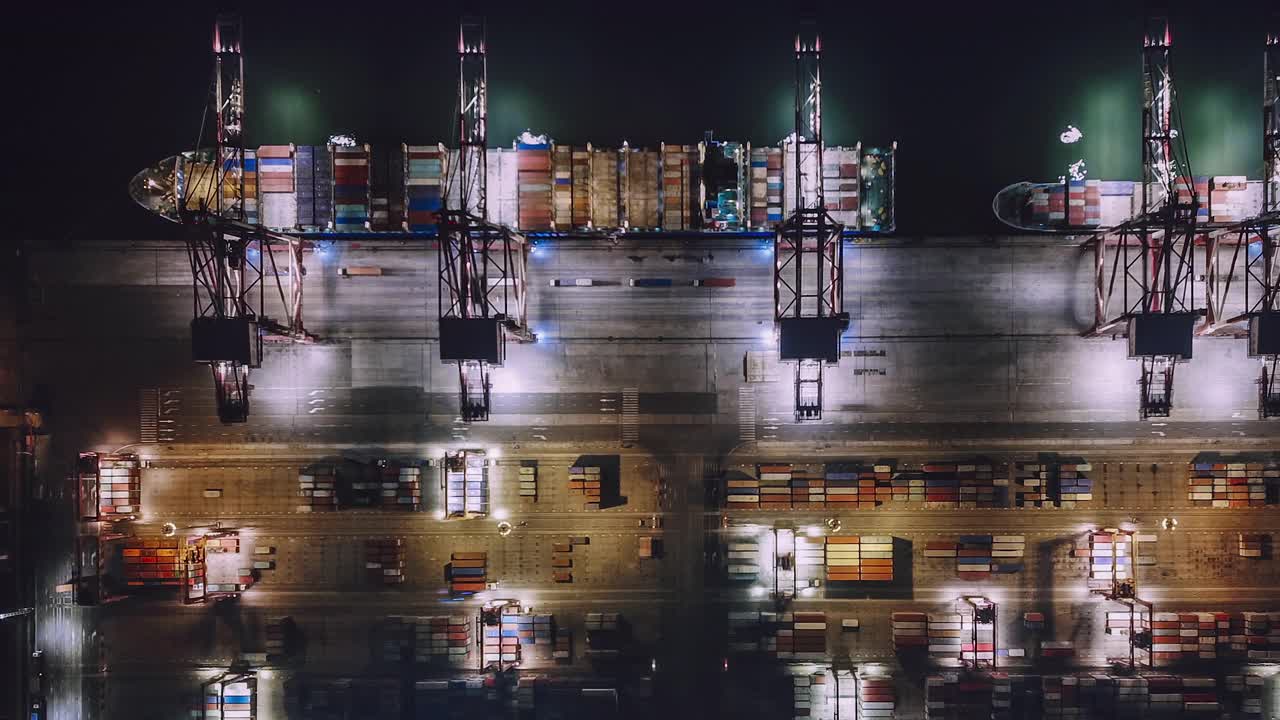 繁忙的工业港口，集装箱船在夜间鸟瞰图视频素材