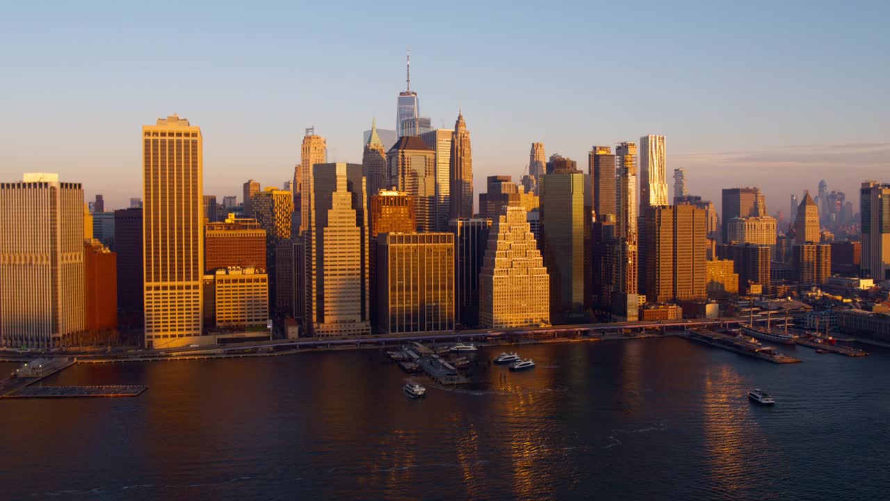 横跨东河的曼哈顿市中心鸟瞰图，黎明时分，轮船从11号码头和炮台海事码头进进出出。无人机视频与平移小车摄像机运动。视频下载