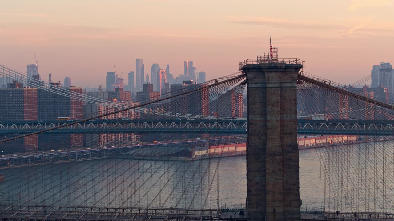 布鲁克林大桥的鸟瞰图，以曼哈顿天际线为背景，被空气透视图模糊，在清晨。无人机视频与向后相机运动。视频素材