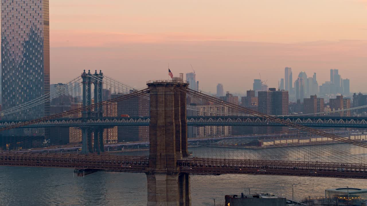 从空中俯瞰布鲁克林大桥，以曼哈顿天际线为背景，在清晨的黎明时分，雾气弥漫。无人机视频与平移摄像机运动。视频素材