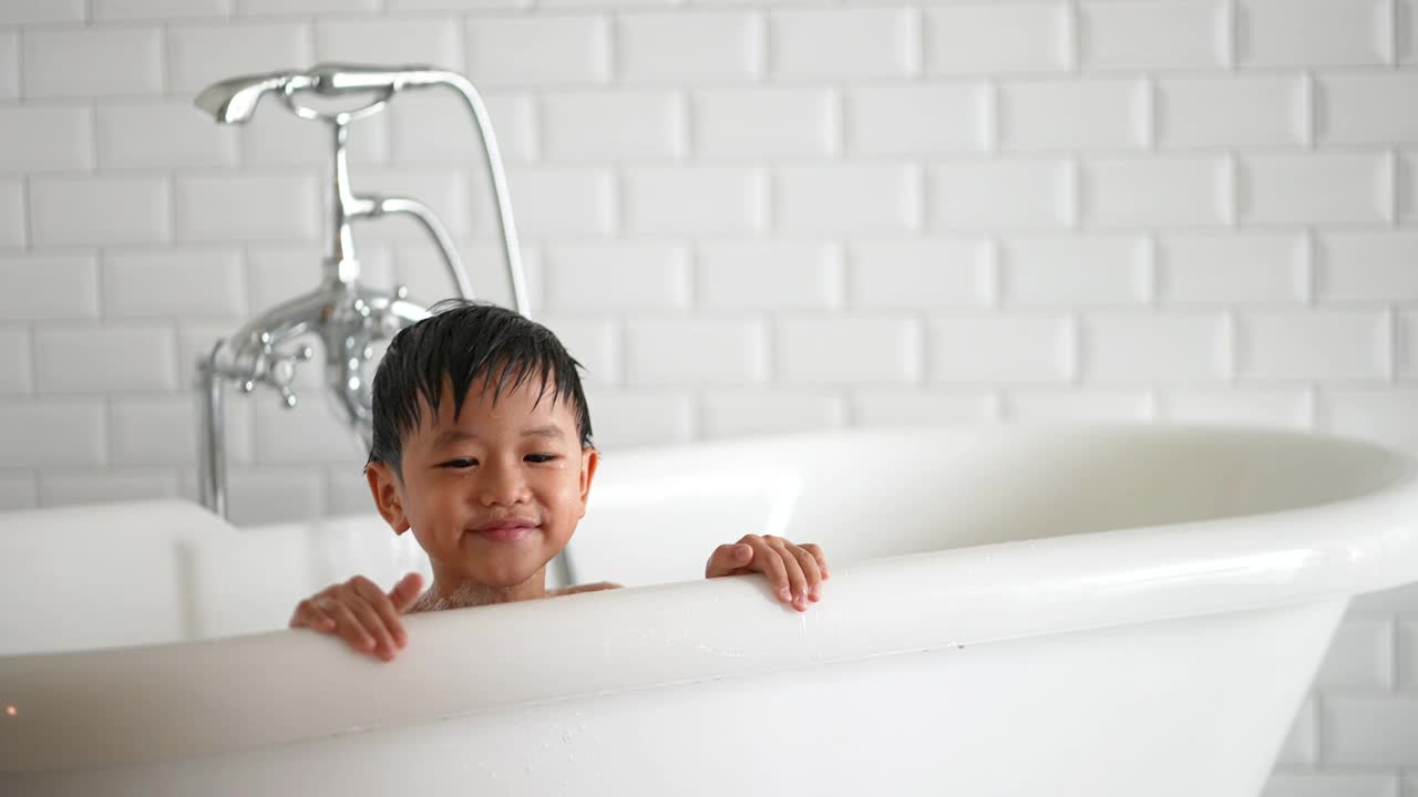 亚洲小孩在浴缸里玩得很开心。健康和幸福的概念视频下载