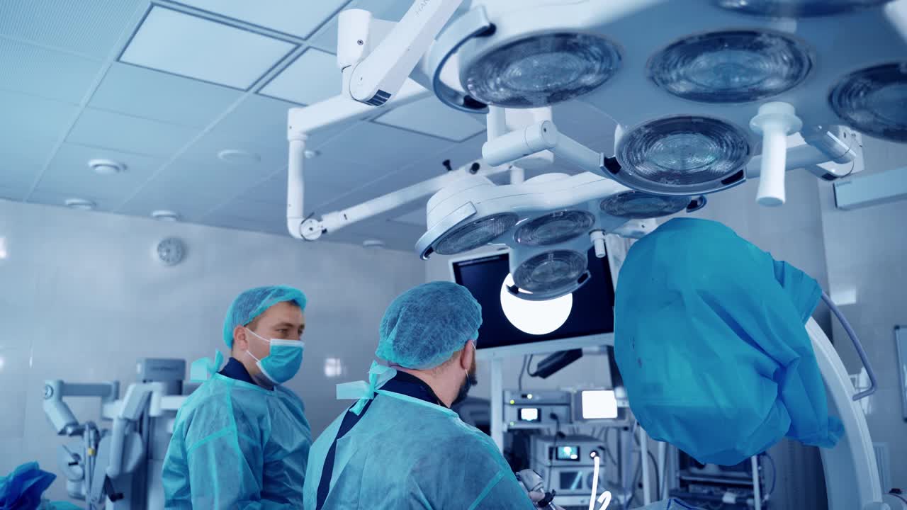 医学专家在现代手术室。医生进行手术并在监视器上观察手术过程。视频素材