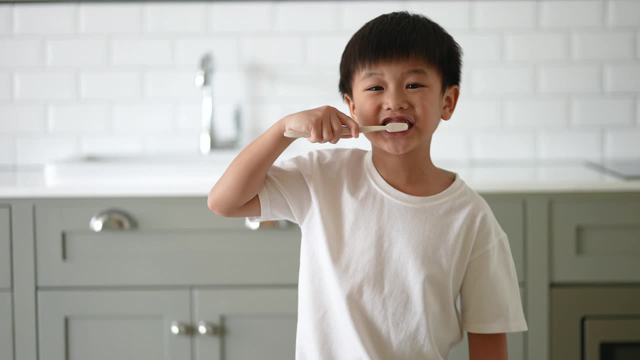 一个亚洲小孩在浴室里刷牙。日常健康和牙科护理的概念视频下载