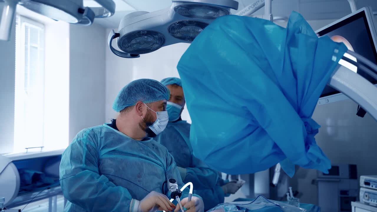 外科医生在手术室挽救病人的生命。现代医院中，身穿制服的专业医生和助手为病人进行手术。视频素材