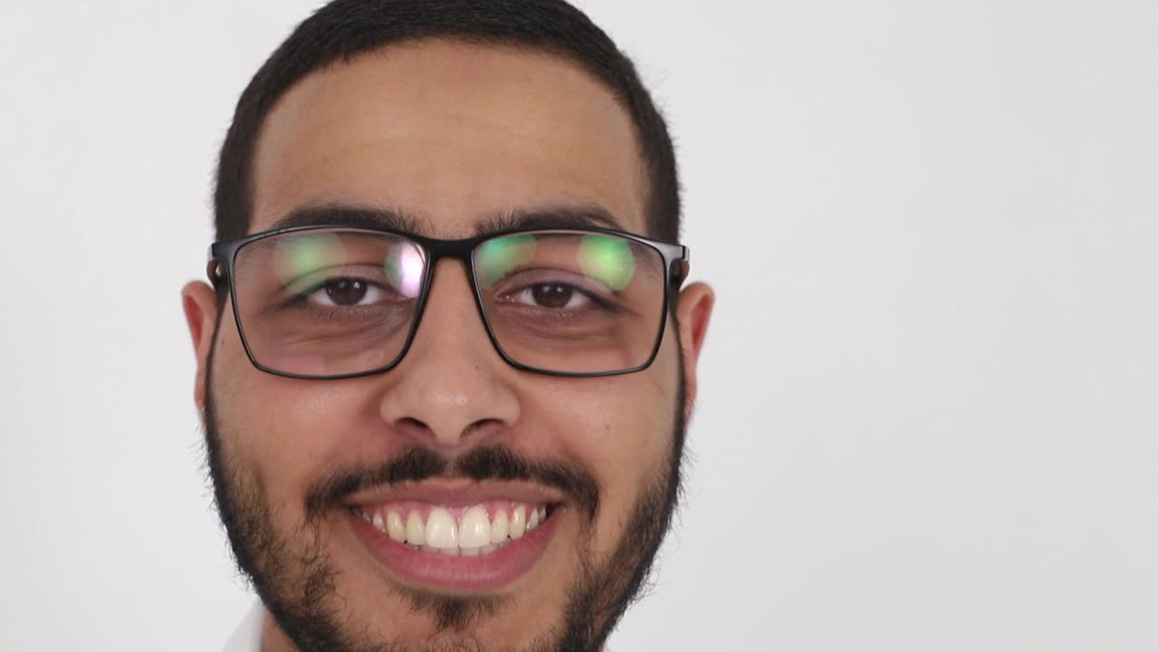 一个年轻的阿拉伯男子站在一个白色背景的特写肖像视频下载
