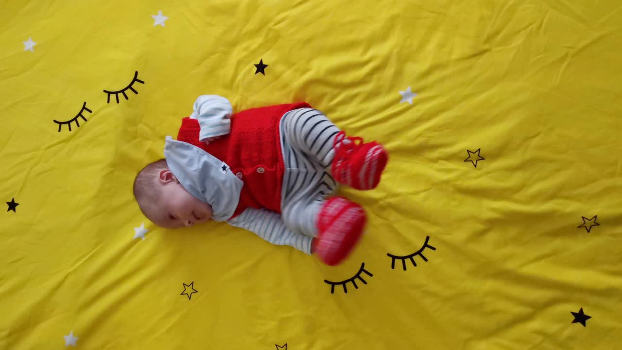 COVID-19大流行期间的新生儿。两个月大的宝宝躺着玩，微笑，四处走动。视频素材
