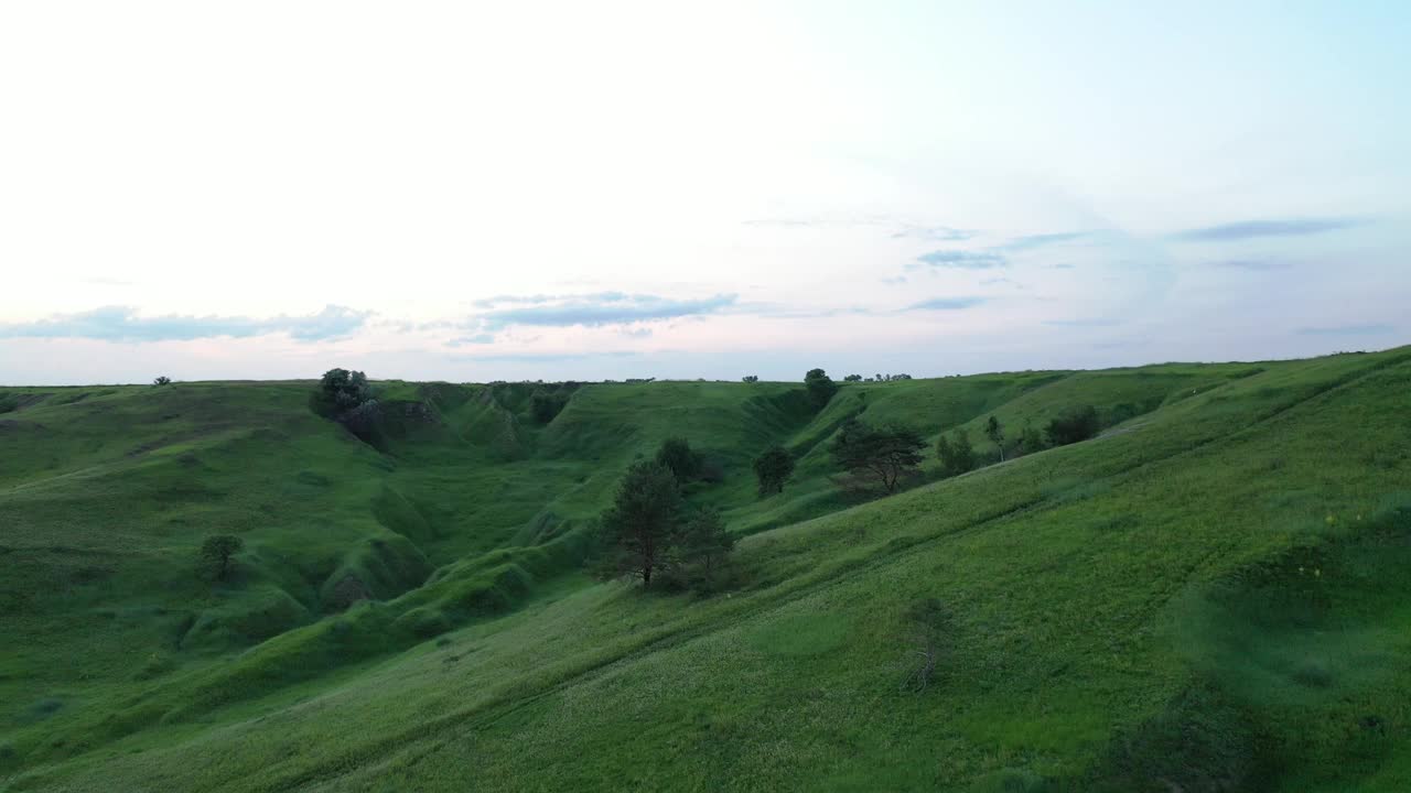 在夏日日落时鸟瞰绿色的峡谷和田野视频素材
