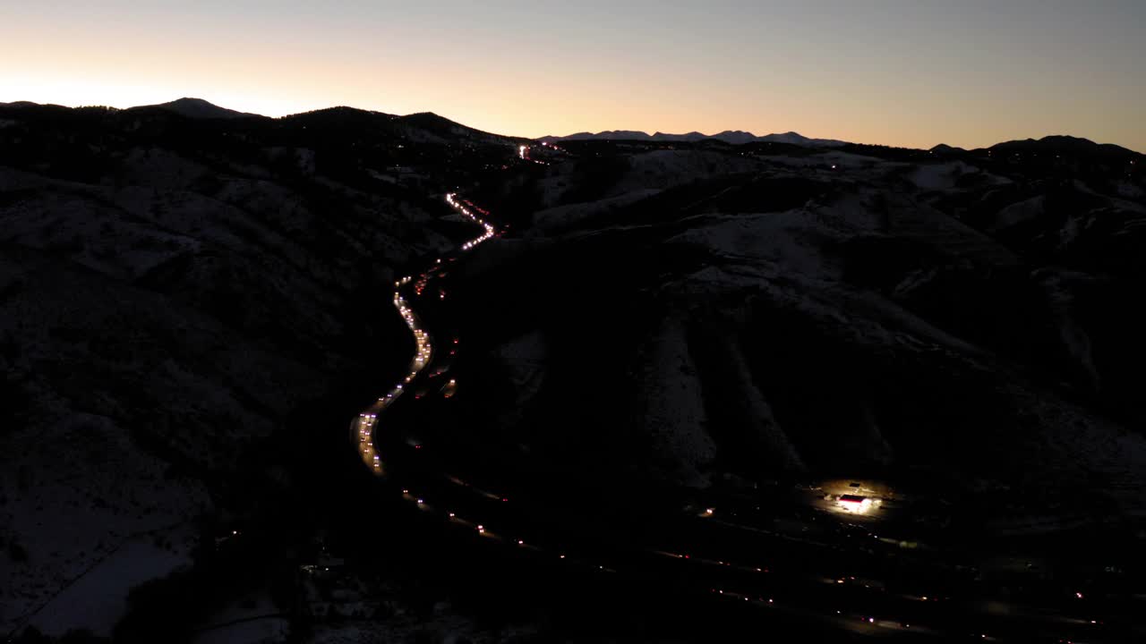 空中拍摄的车辆移动在黄昏在山麓的高速公路上，无人机在景观上平移-丹佛，科罗拉多州视频下载