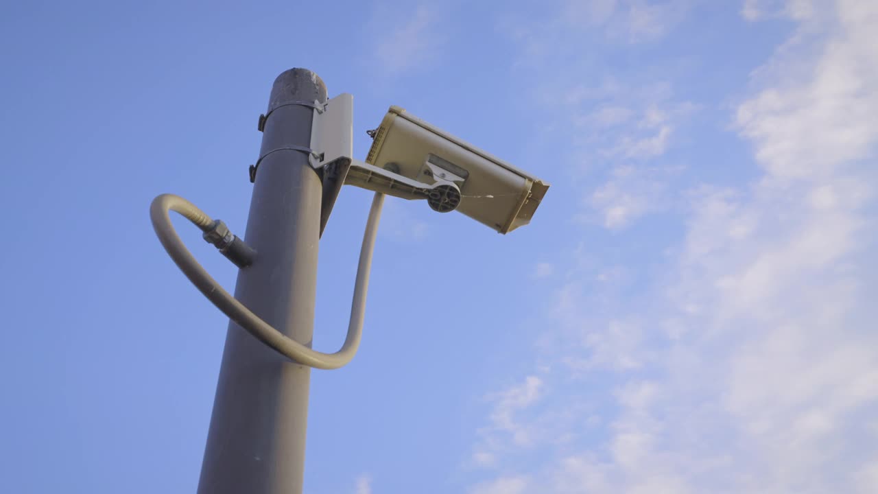安全摄像头闭路电视视频监控安装在极端钢杆和清晰的蓝天背景视频素材