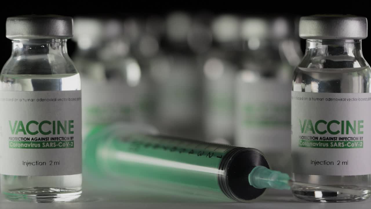 研究实验室，医生从救治新冠肺炎疫苗瓶中取出注射器。大流行疫苗接种的概念。宏观，医用防护手套。玻璃瓶,瓶子,SARS-Cov-2视频素材