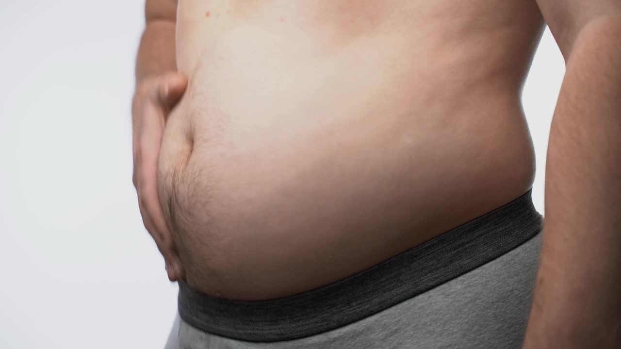 男性大肚子的特写。那个胖子检查了他的腰视频下载