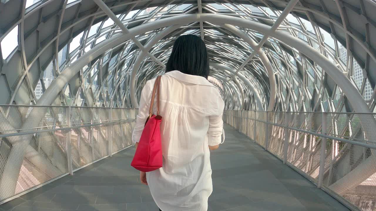 后视图亚洲华人中年妇女在人行天桥外戴防护面罩视频素材