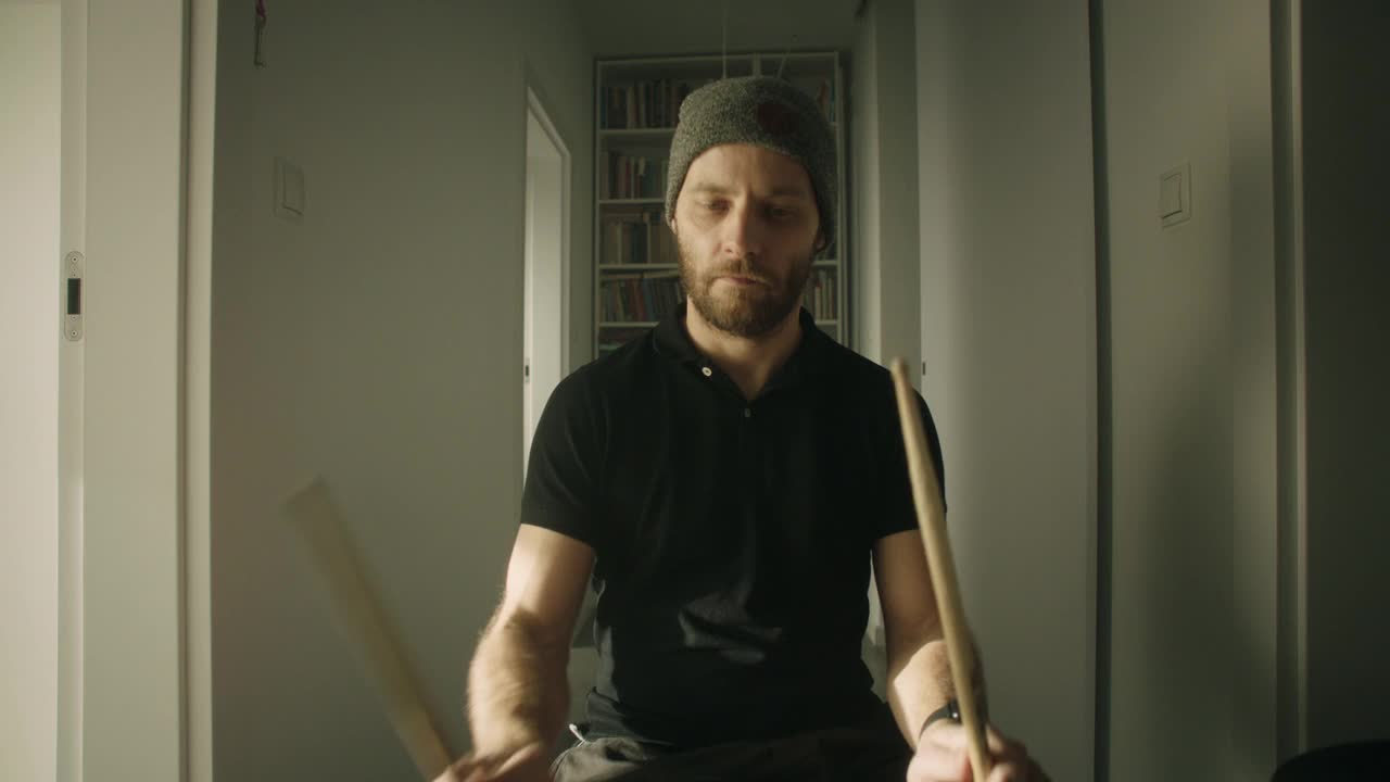 一个男人在他的客厅里练习电子鼓。前视图视频下载
