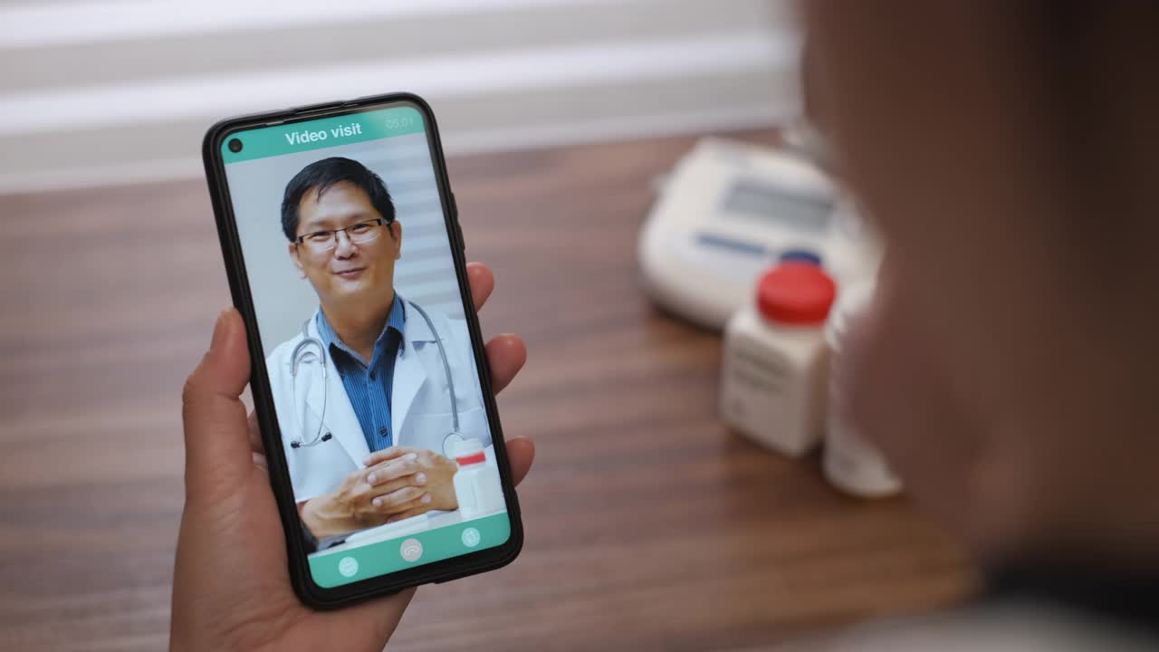 亚洲病人与她的医生视频通话，在家里使用药片要求处方，病人有一个关于她的疾病的视频访问顾问。视频素材