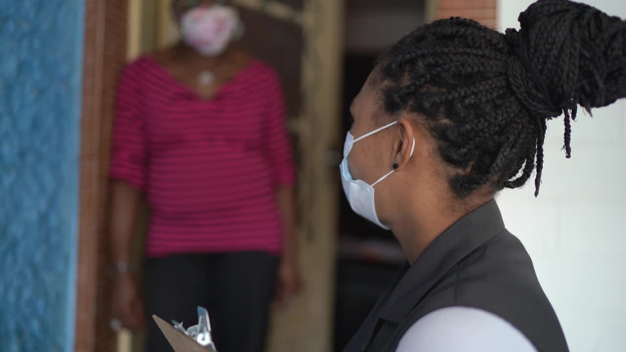 女测量员的肖像在门口的一个高级妇女家里戴着面具视频素材
