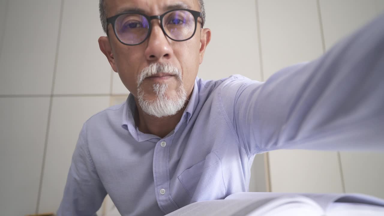亚洲华人资深男教授家教老师听他的成人学生使用笔记本电脑在家里工作视频素材