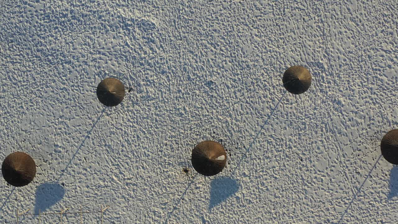 冬天海滩的俯视图，雪地里的脚印，蘑菇的影子。无人机拍摄的照片。视频下载