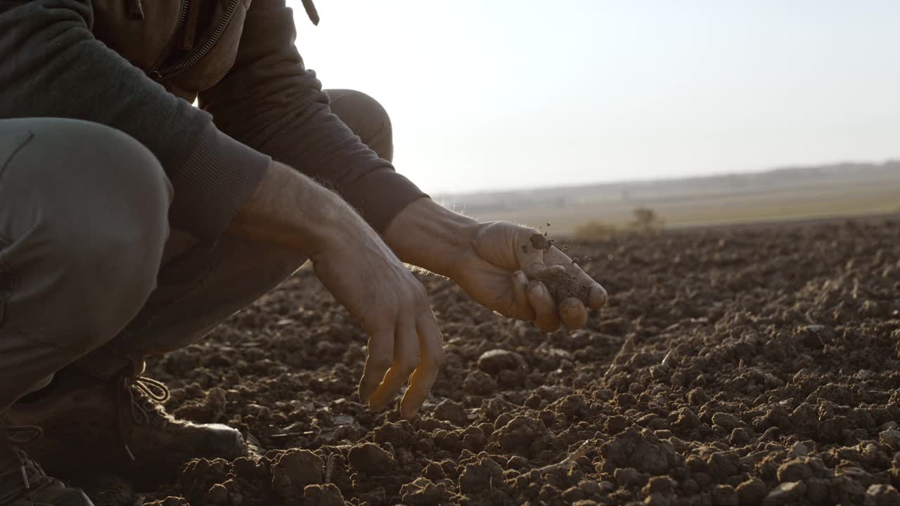 农民在检查田里的泥土视频素材