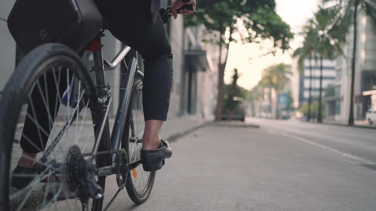 近距离的脚商人是骑自行车在城市的街道上为他的早晨通勤工作。生态交通的概念。视频下载