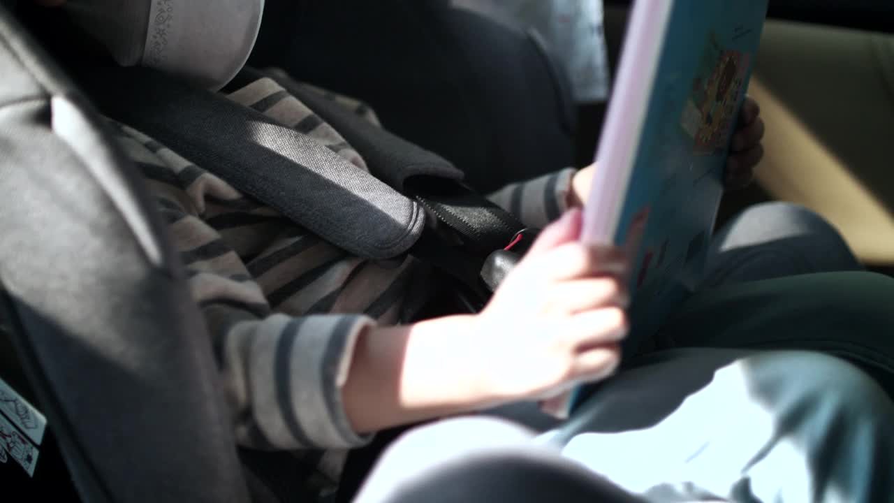 小男孩戴上口罩，坐在汽车座椅上准备踏上旅途视频素材
