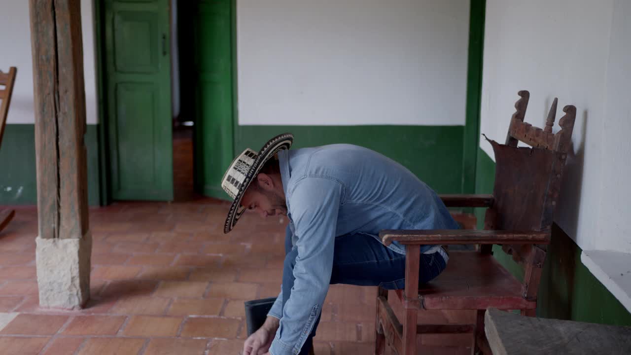 年轻的男性农民正准备在咖啡农场换靴子视频素材