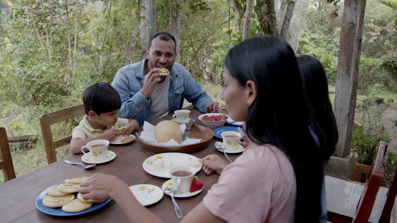 一对幸福的夫妇和他们的两个孩子在农场享受美味的早餐视频素材