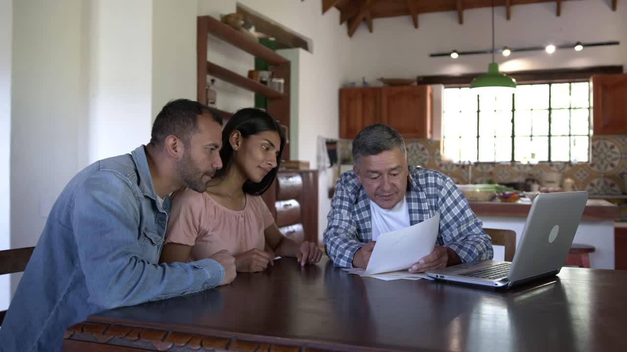 拉丁美洲的雇主与在他的土地上作为监督者工作的一对夫妇交谈，并向他们展示财务文件视频素材