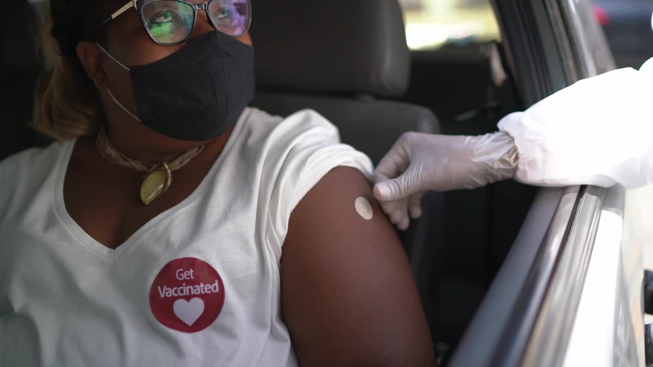 一个女人衬衫上的"接种疫苗"贴纸视频下载