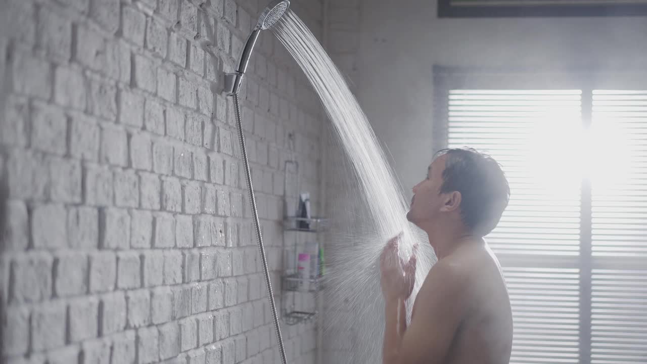 英俊的亚洲人在浴室洗澡他正在洗他的头发视频素材