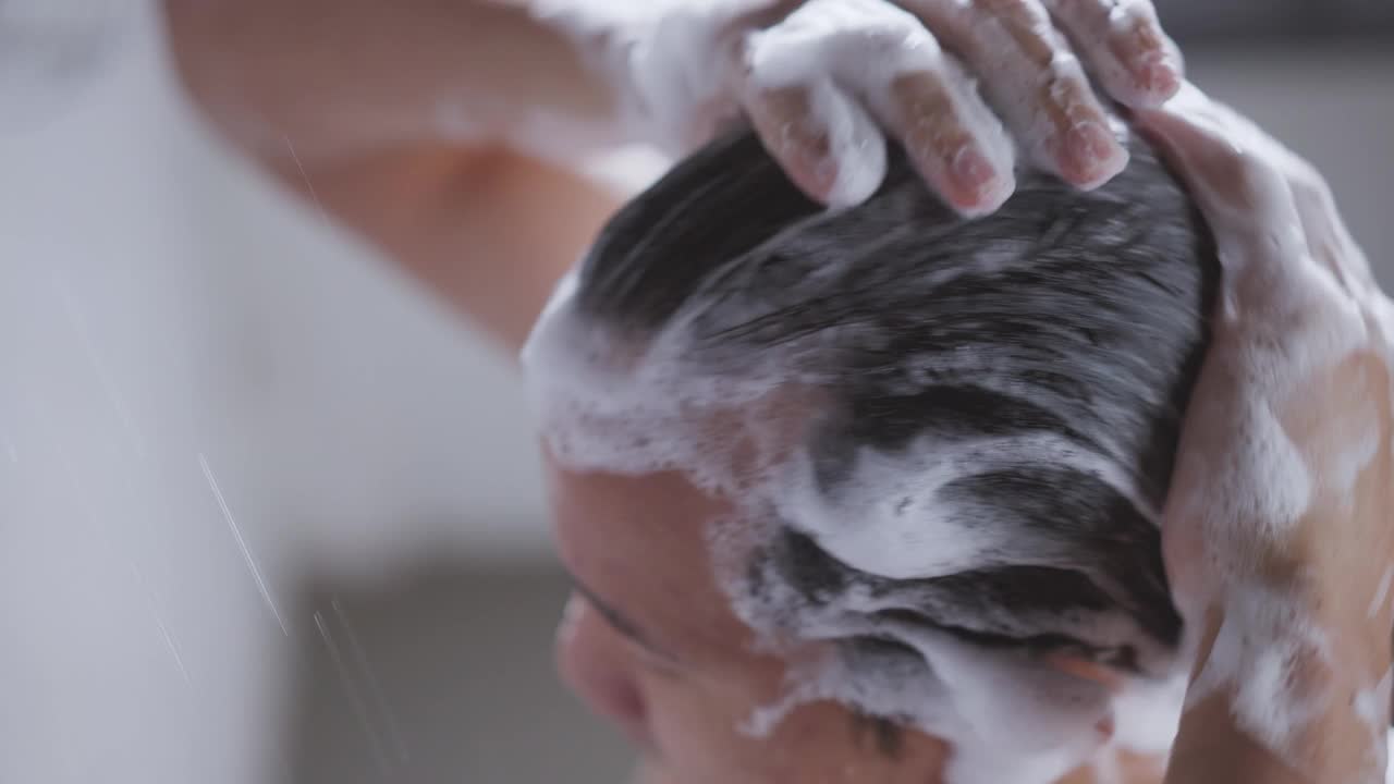 英俊的亚洲人在浴室洗澡他正在洗他的头发视频素材