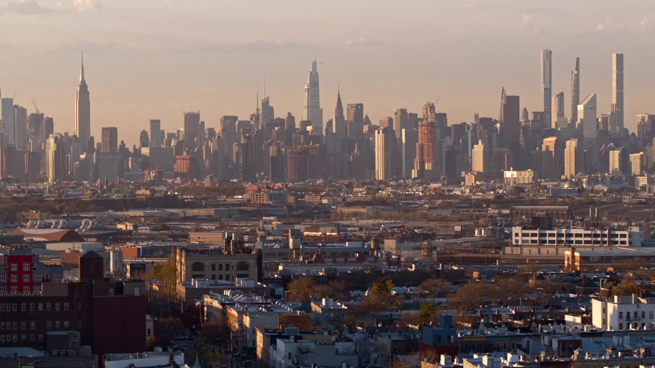 在阳光明媚的傍晚时分，俯瞰纽约布鲁克林布什维克住宅区的曼哈顿中城。无人机视频与平移摄像机运动。视频素材