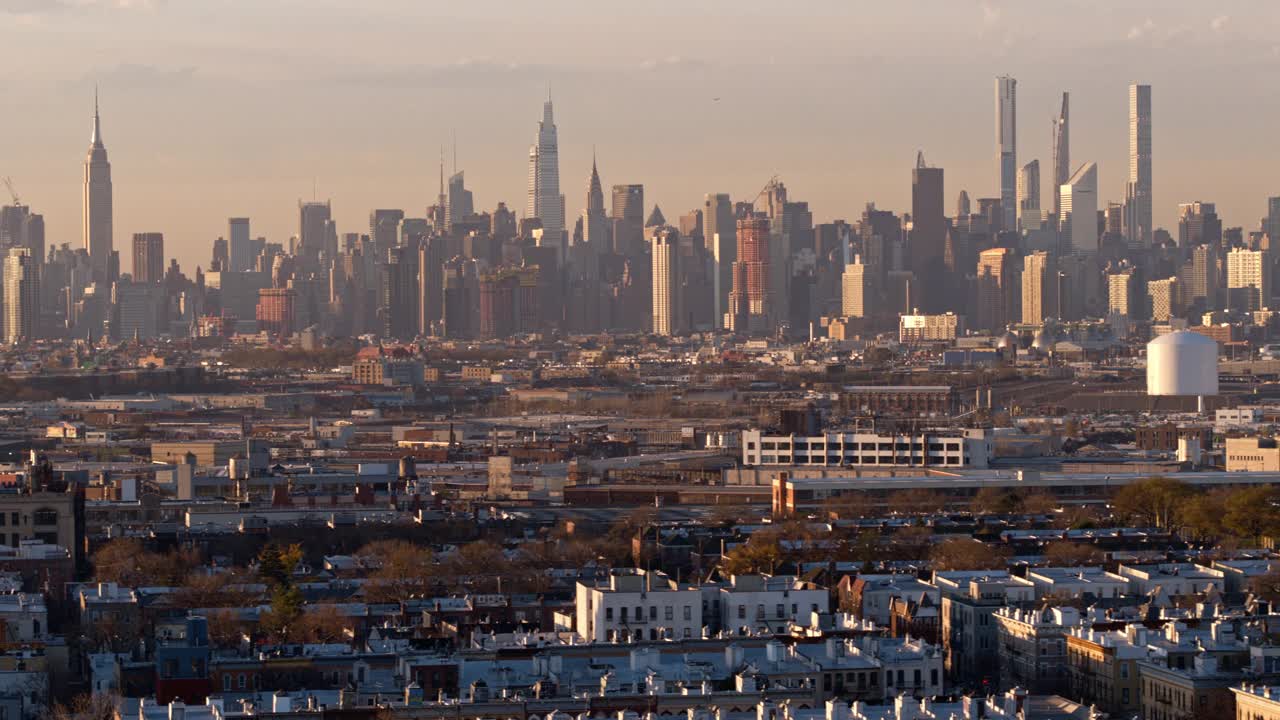 在阳光明媚的傍晚时分，俯瞰纽约布鲁克林布什维克住宅区的曼哈顿中城。无人机视频与平移摄像机运动。视频素材