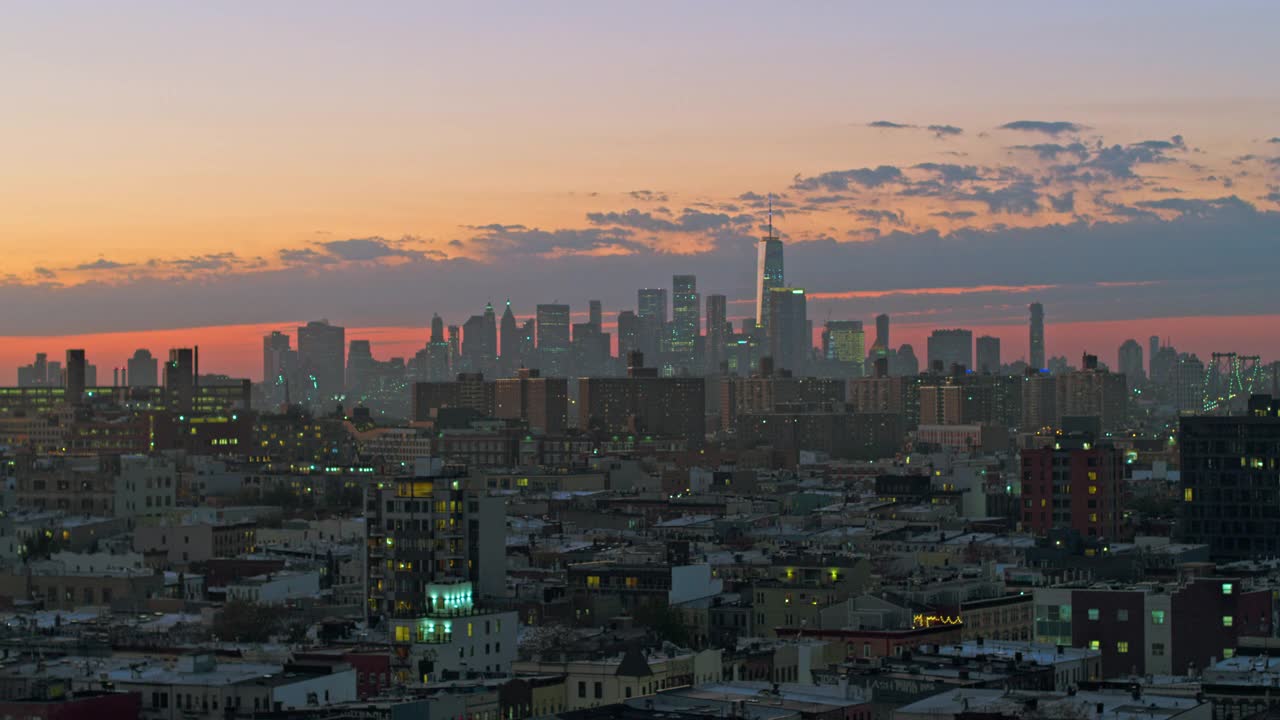 曼哈顿下城和自由塔在日落时照亮了布鲁克林住宅区。无人机视频与平移摄像机运动。视频素材