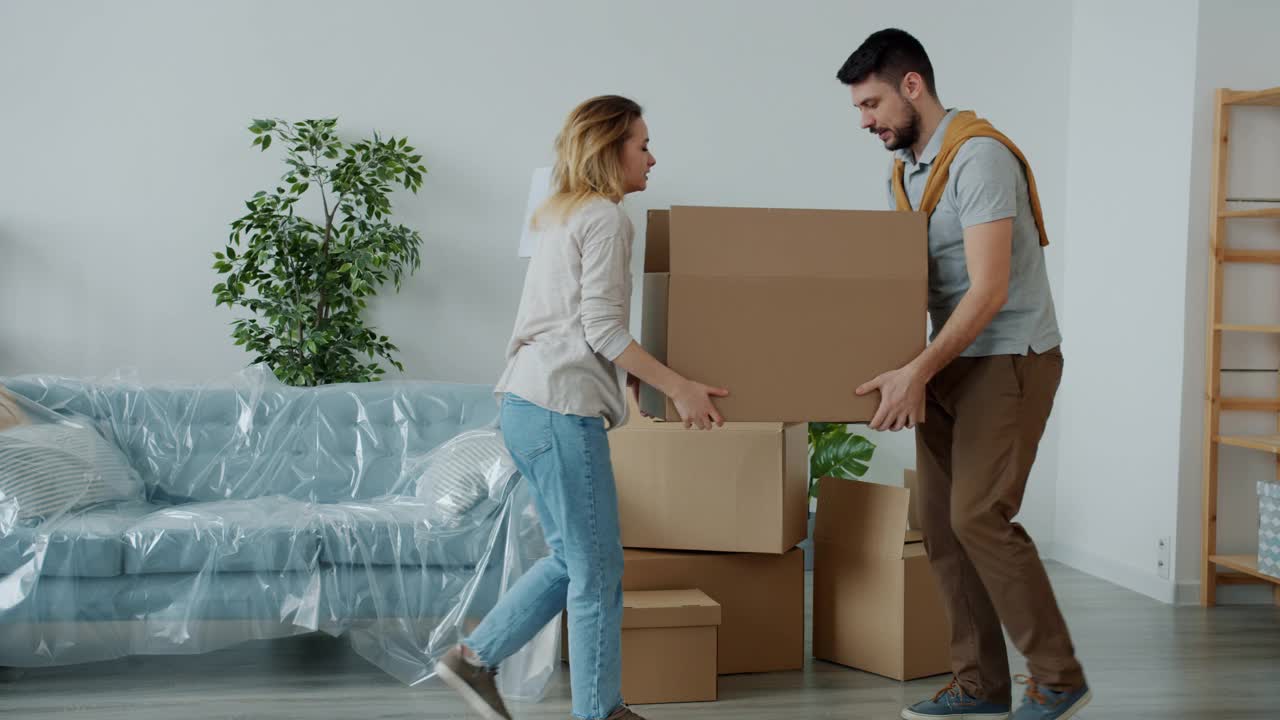 男人和女人扛着沉重的箱子去新房子和忍受背痛的感觉不好视频素材