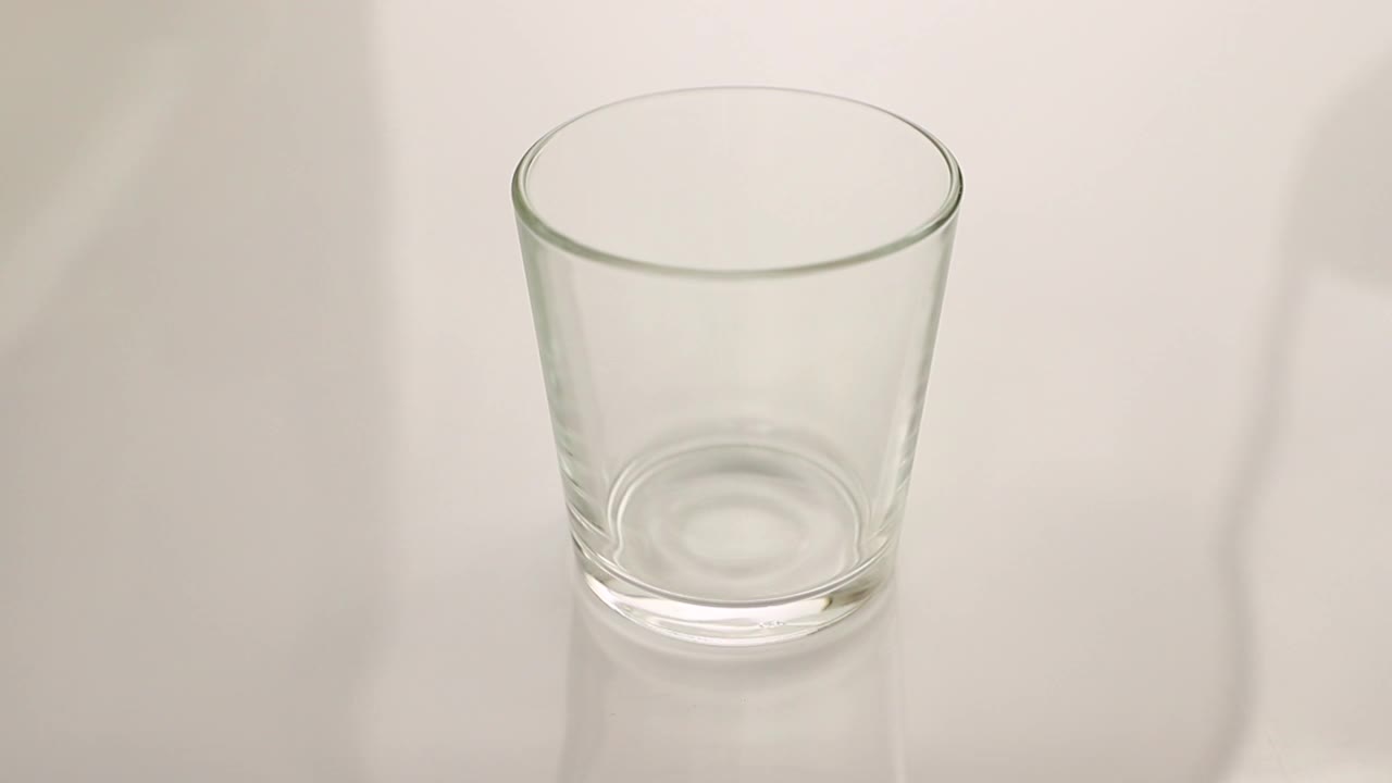 牛奶或蔬菜牛奶倒入透明的玻璃在白色的背景近距离视频下载