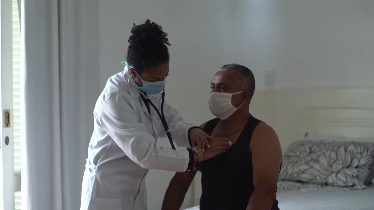 医生在家访时听病人的心跳-戴口罩视频素材