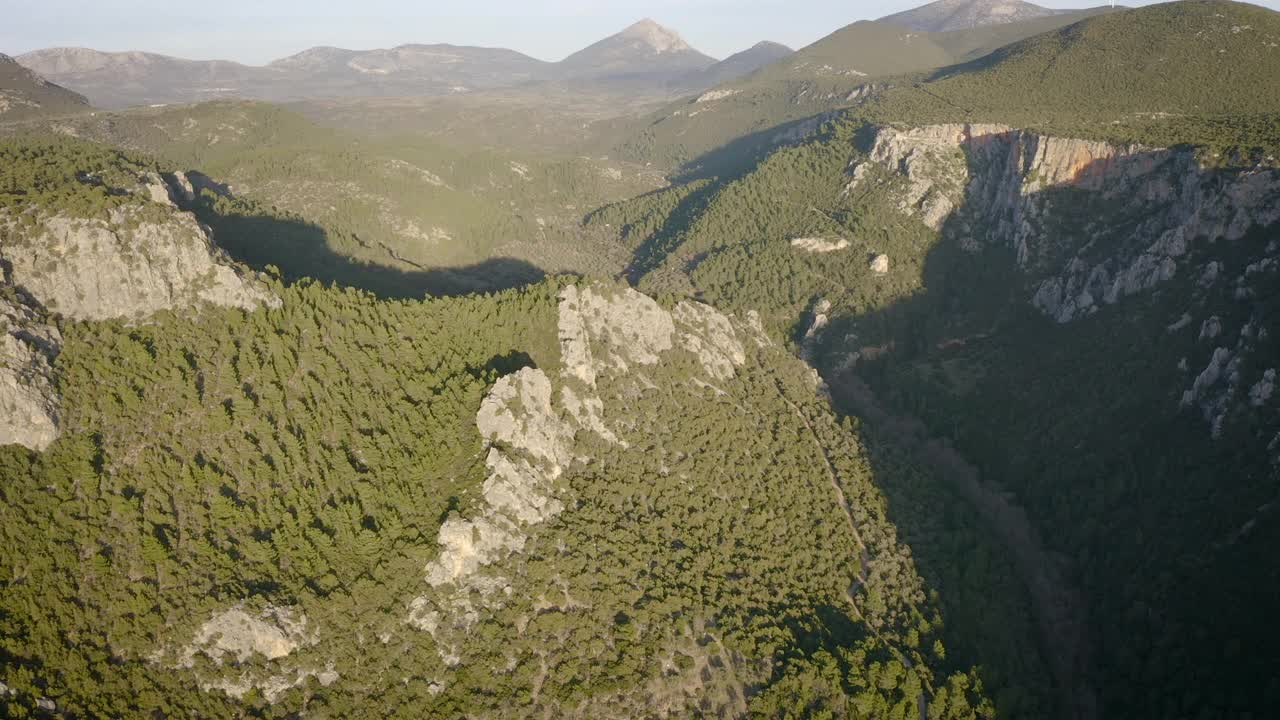 无人机绕着树木覆盖的山顶飞行视频素材