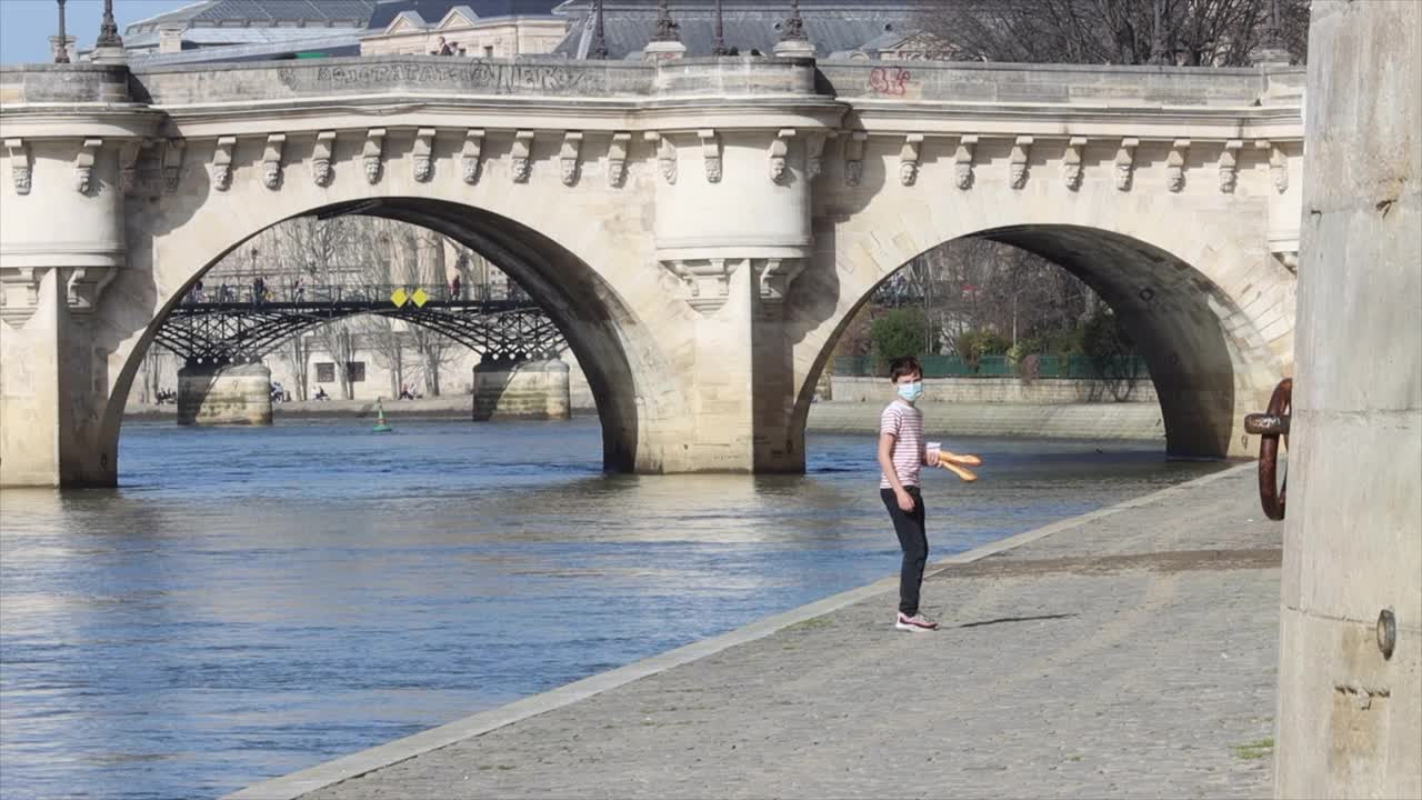 一个拿着法式长棍面包的孩子，走在巴黎塞纳河岸边视频下载