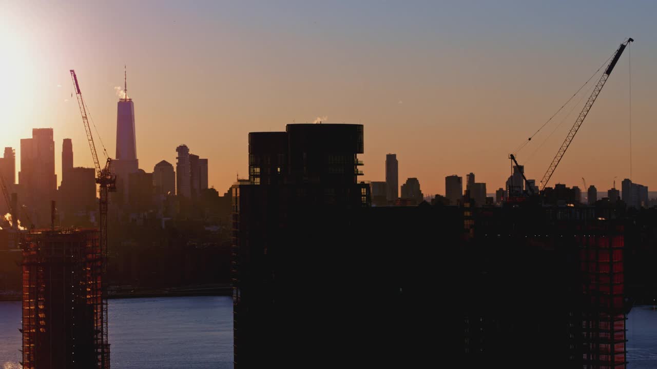 布鲁克林滨水区新建住宅楼，日落时分，可以看到曼哈顿下城的天际线和自由塔的美景。航拍视频与平移摄像机运动。视频下载