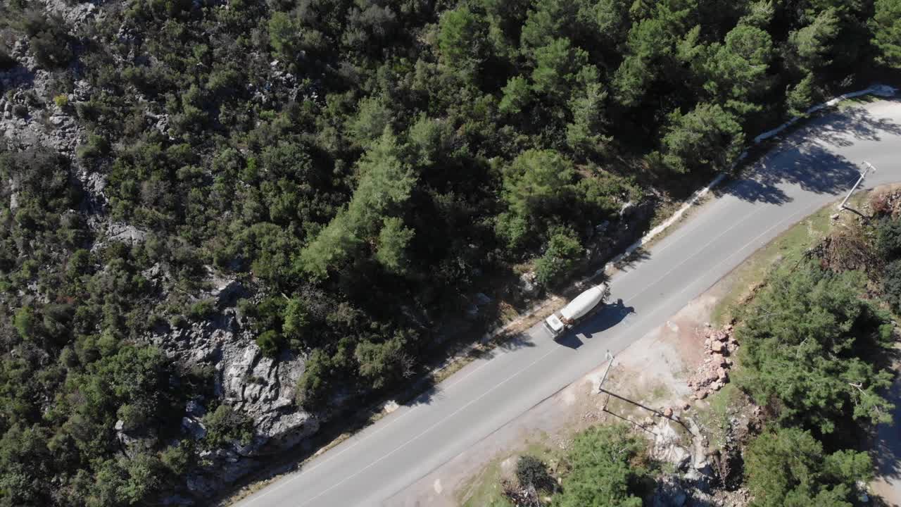 卡车正行驶在山间空车路上，顶部鸟瞰图。一辆白色卡车正驶过山口视频素材