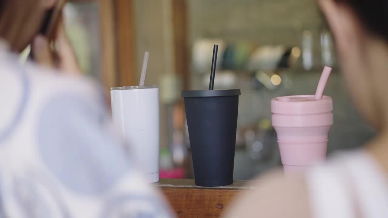 3个可重复使用的旅行杯放在咖啡馆柜台吧台上视频素材