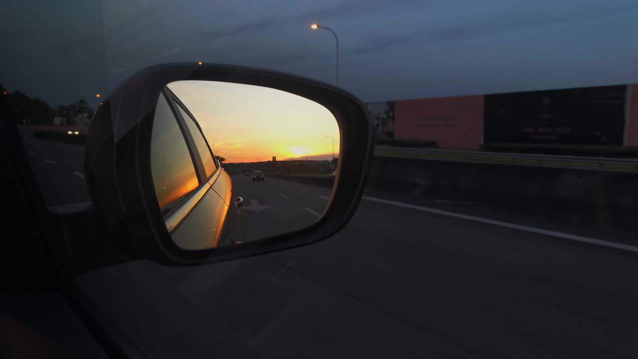 一辆车的后视镜显示美丽的日落视频素材