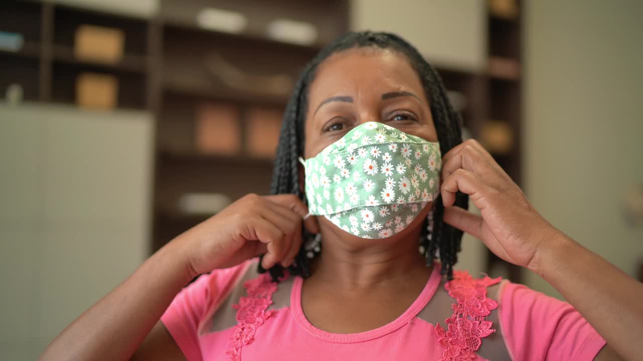 一个成熟的女人在家里摘下保护面罩的肖像视频素材