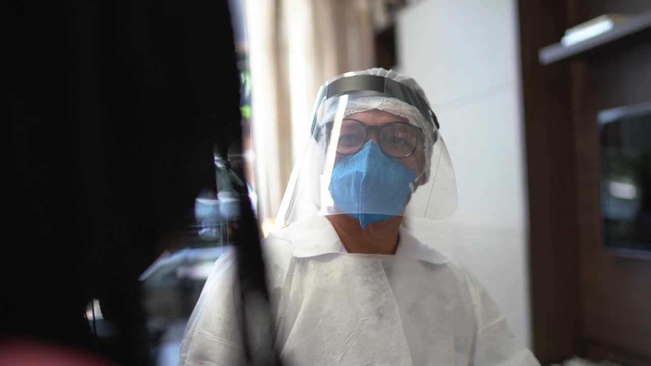 医生穿著防护服在家探望病人视频素材